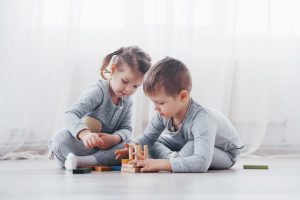Barn leker med en leksaksdesigner på golvet i barnrummet.